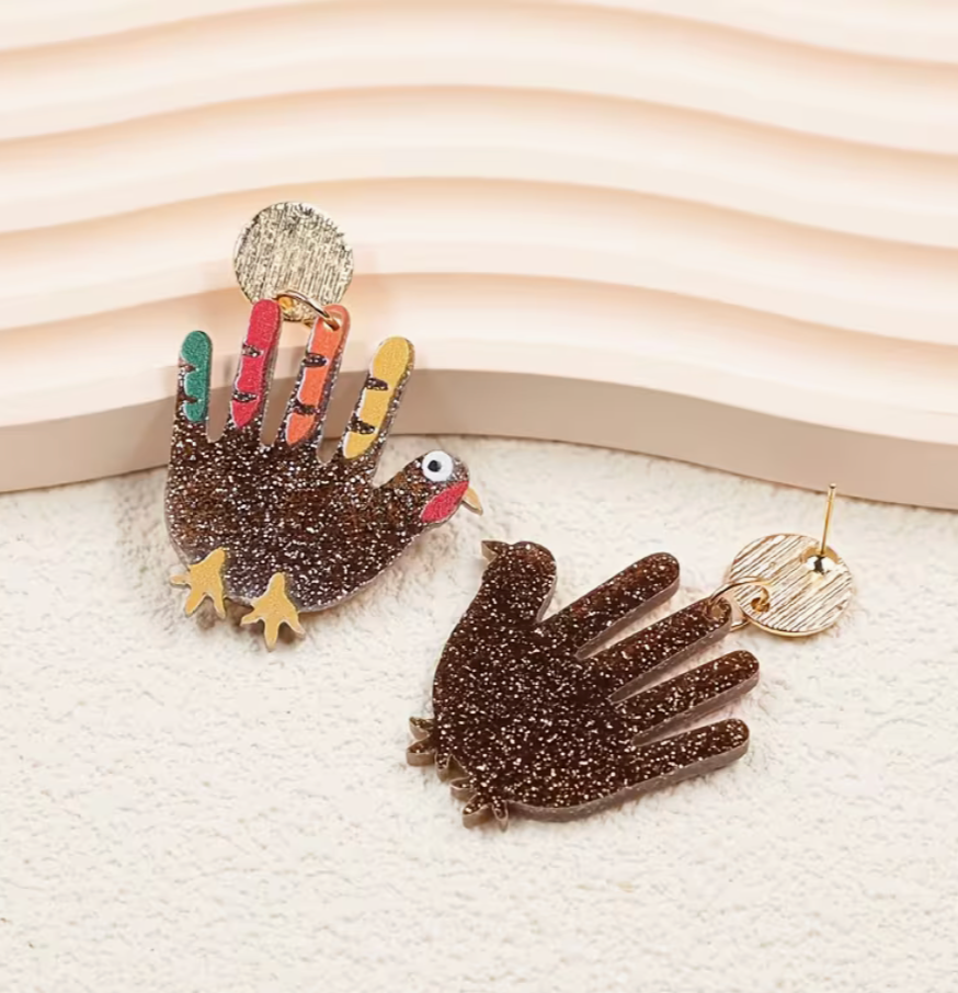 front and back view of sparkling turkey earrings with colorful feathers