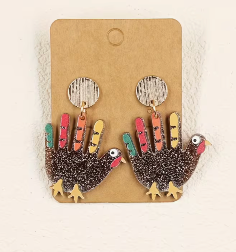 Pair of glitter turkey earrings displayed on kraft card with colorful feathers