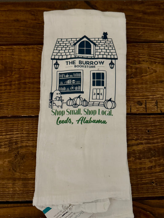Towel with 'The Burrow Bookstore' design on a wooden surface