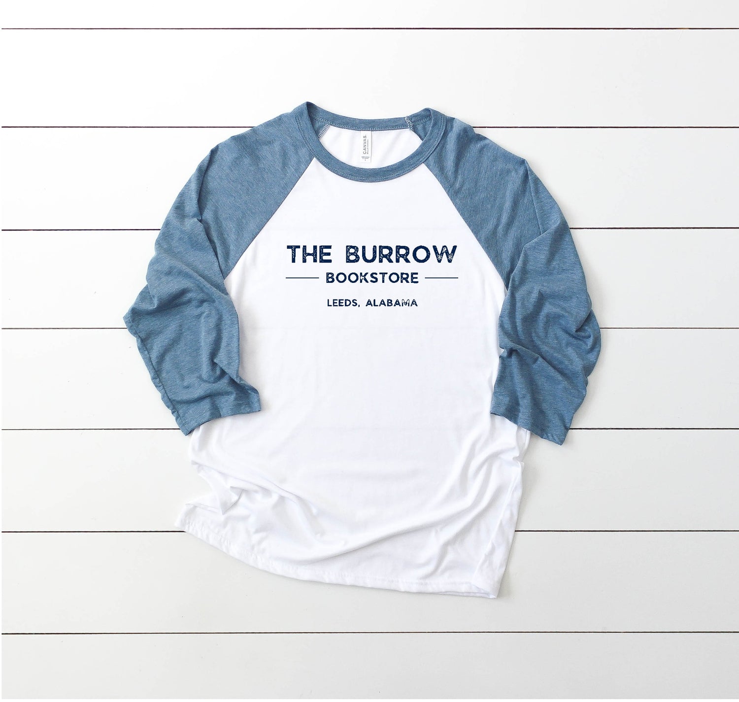 3/4-sleeve raglan t-shirt with The Burrow Bookstore, Leeds AL logo, perfect for book lovers and small-town supporters.