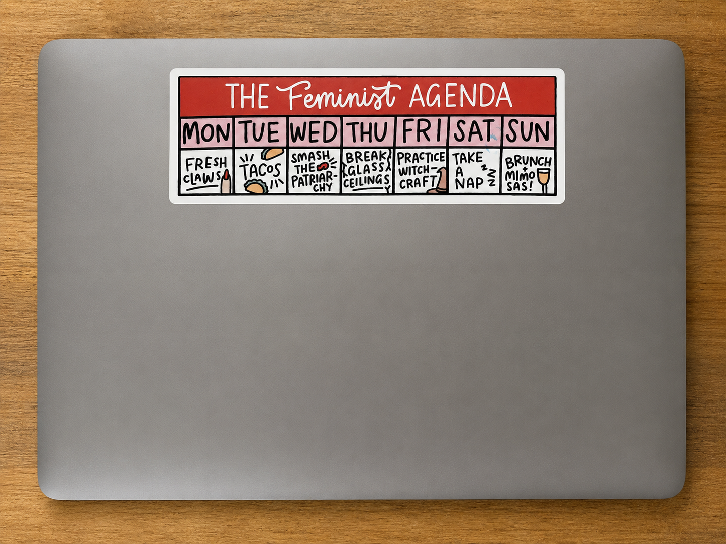Rectangular die cut sticker featuring a humorous Feminist Agenda weekly planner design displayed on a laptop.