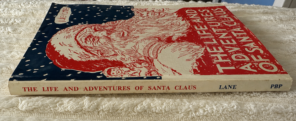 Spine view of the vintage paperback edition of The Life and Adventures of Santa Claus by Julie Lane, showing the book's thickness and spine lettering.