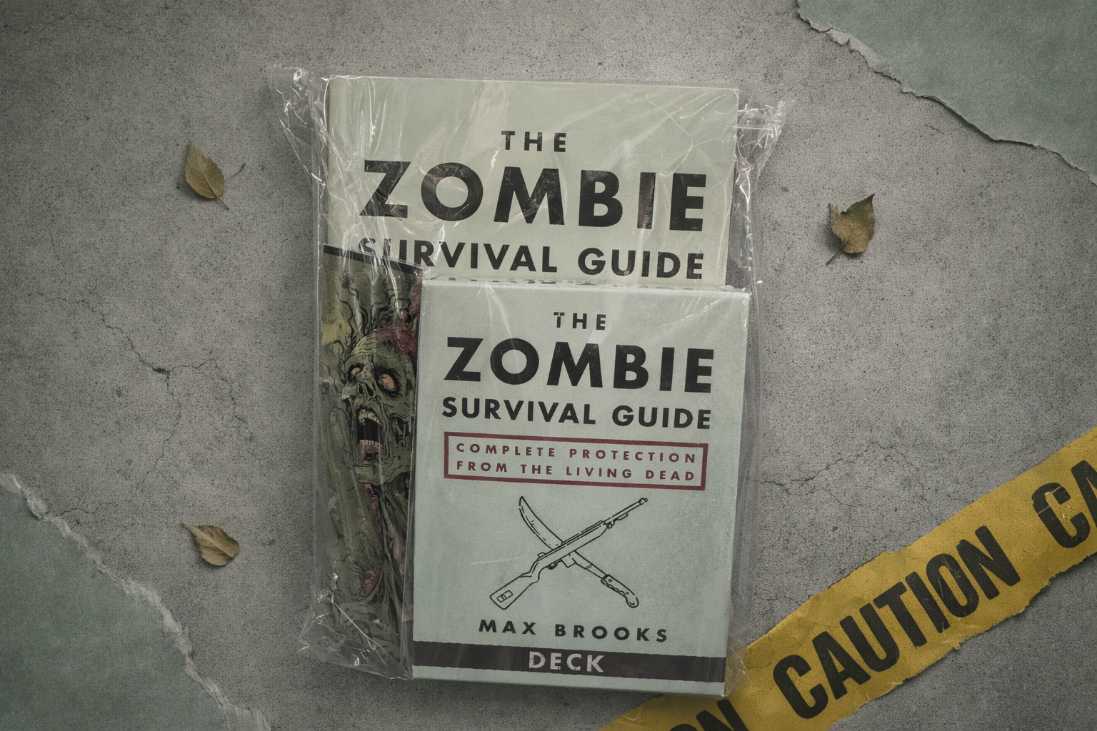 Zombie Survival Guide deck packaging on a textured surface with caution tape.