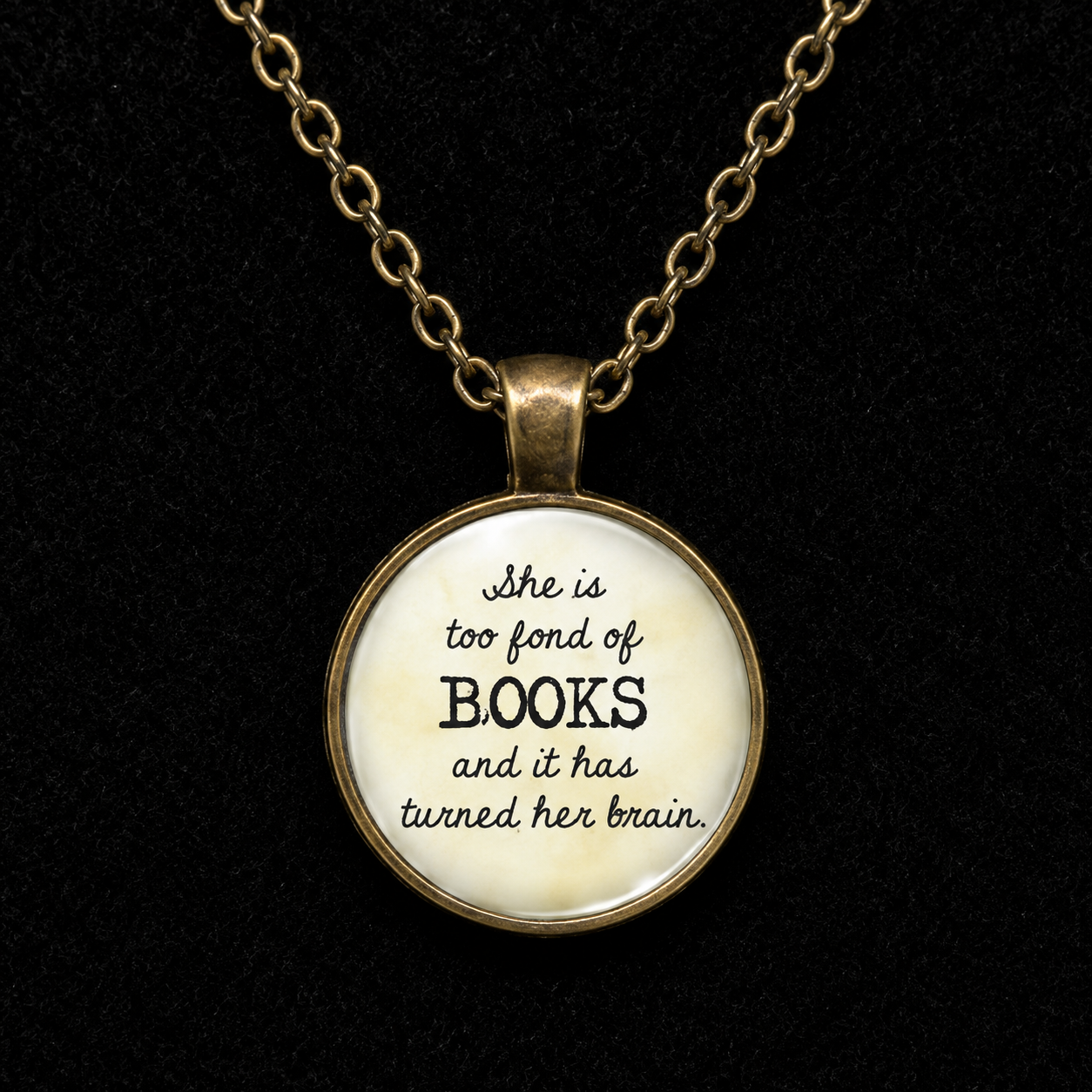 Vintage bronze-tone book lover necklace featuring She Is Too Fond of Books quote in a round glass pendant with matching chain.