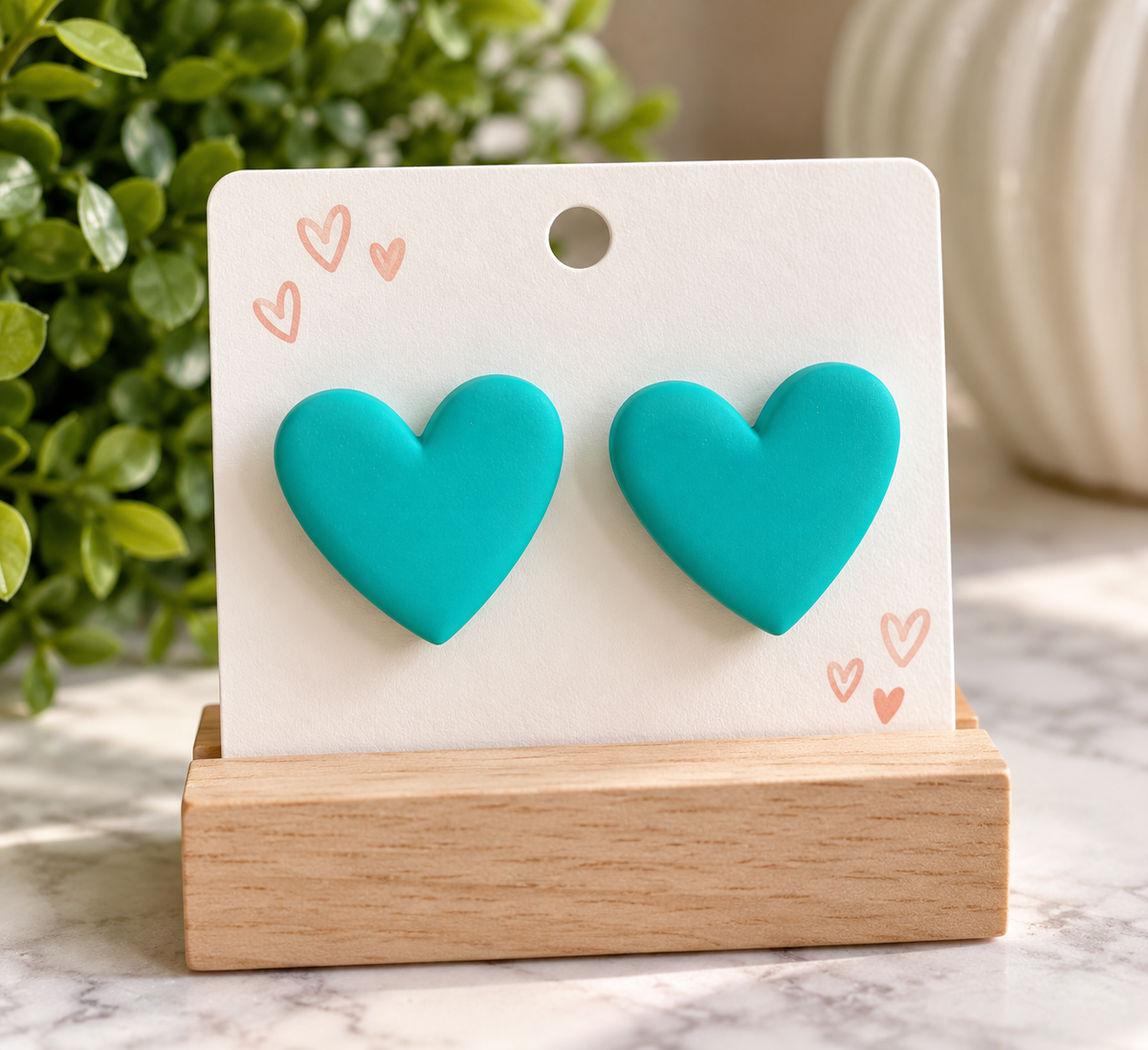 Oversized turquoise lake green acrylic heart stud earrings with smooth solid-color finish measuring 1.5 inches tall