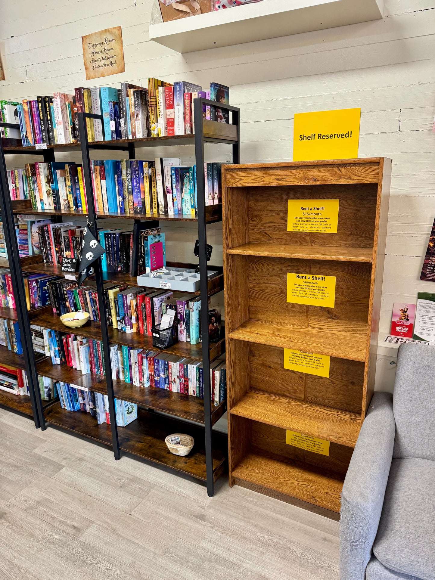Vendor shelf rental bookcase positioned next to bookstore bookshelves and reading area.
