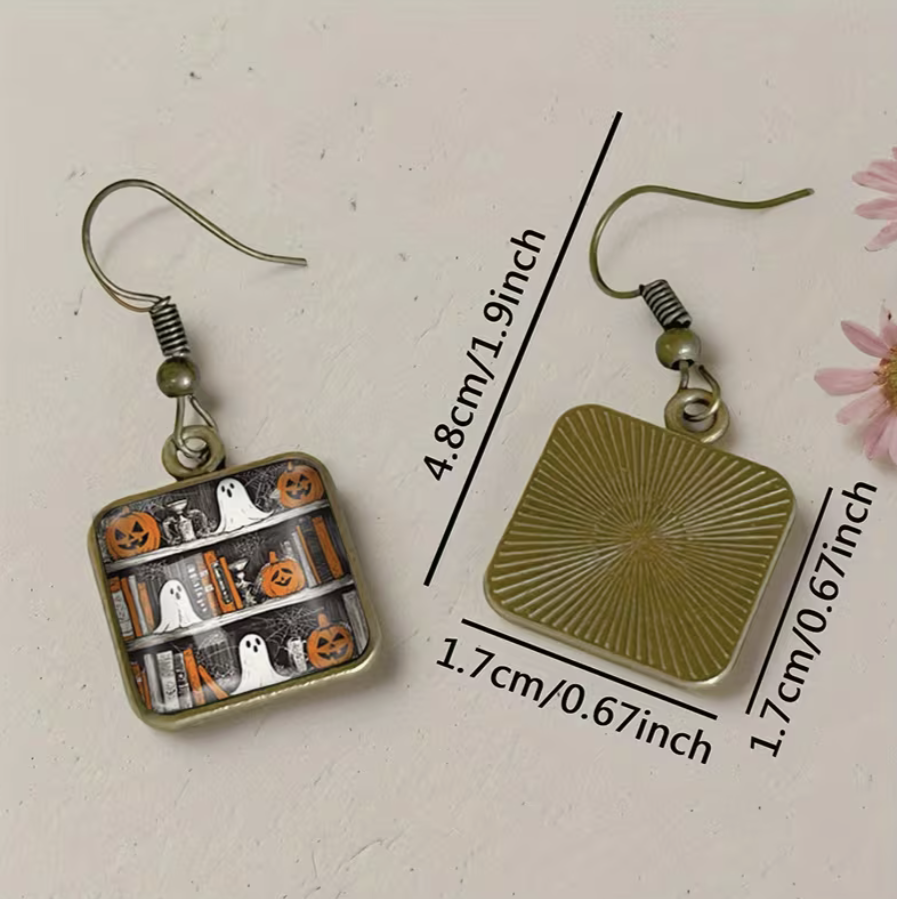 Halloween-themed earrings with measurements on a light background
