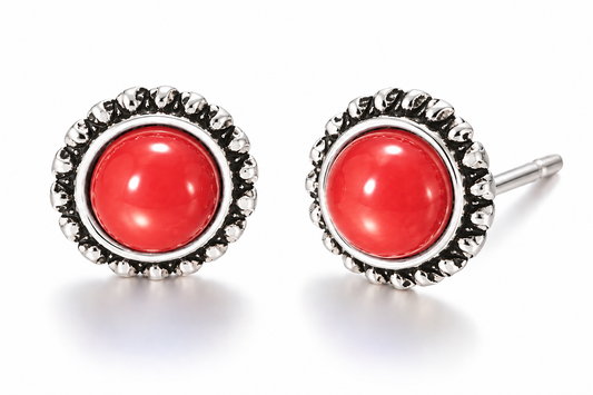 Pair of vintage-inspired red cabochon stud earrings featuring glossy round red centers surrounded by ornate antique silver-tone sunburst settings on a white background.