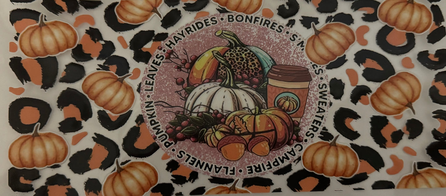 Decorative mat with pumpkins, corn, and a central design on a patterned background.