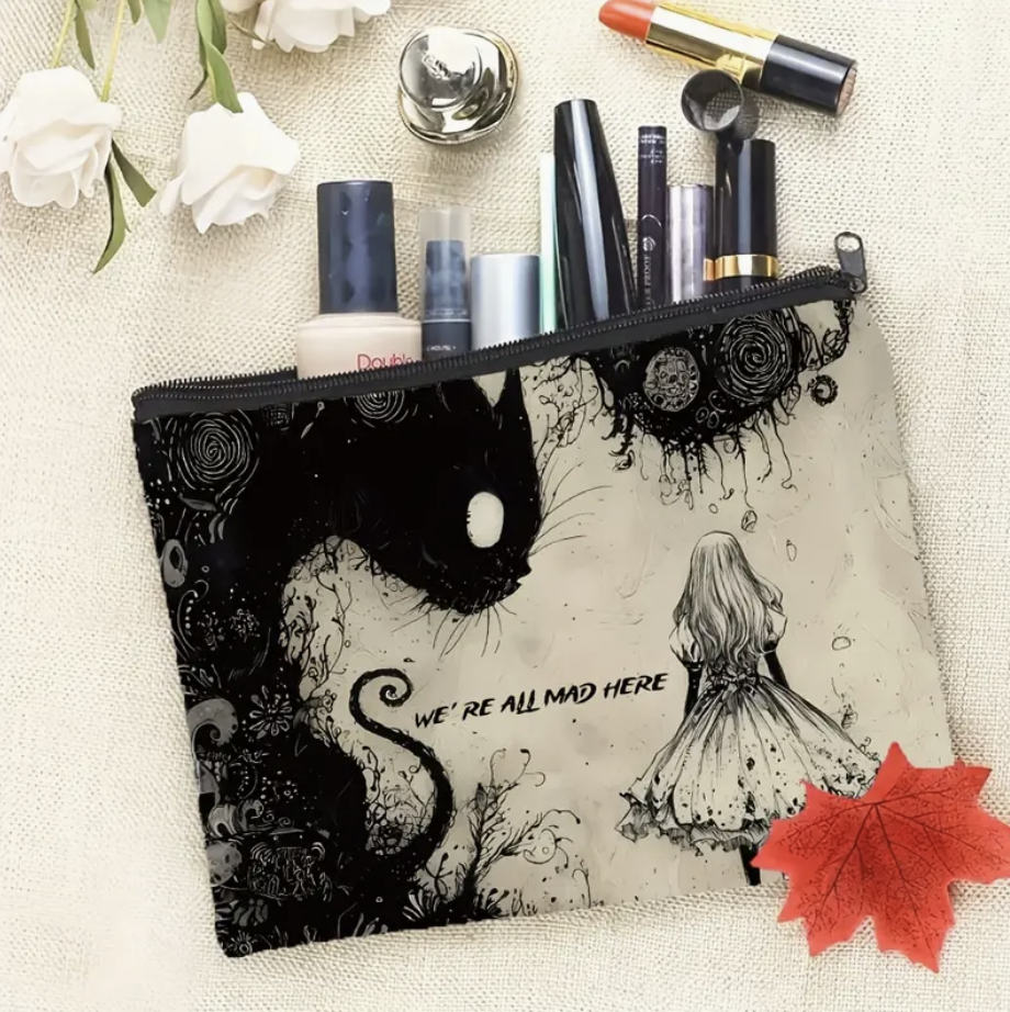Makeup bag with artistic design of a black cat and a girl, containing makeup items.