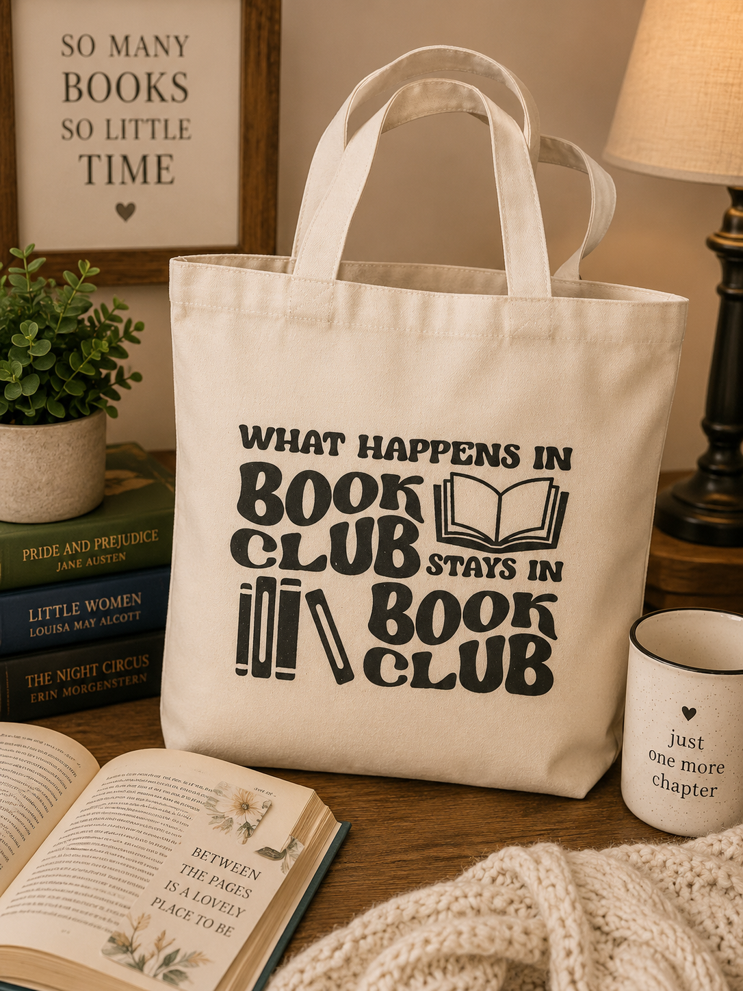 Canvas tote bag with the funny phrase "What Happens in Book Club Stays in Book Club" displayed in a cozy bookish setting with classic books and coffee.