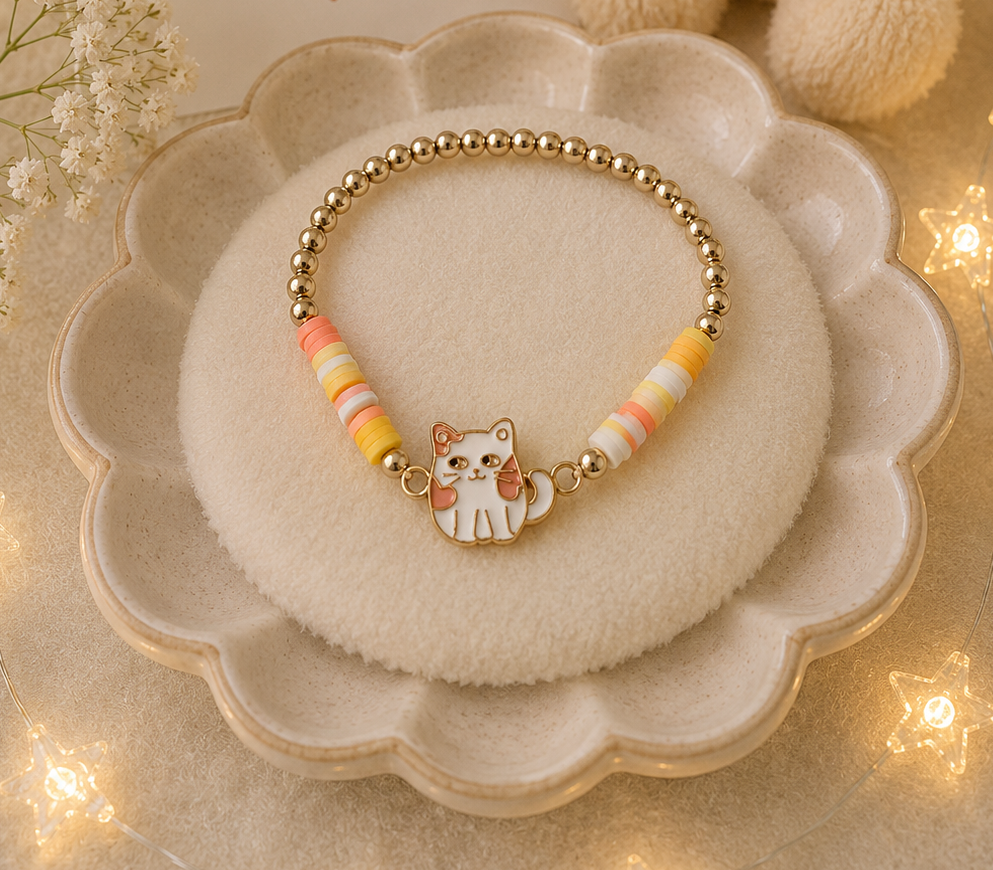 White kitten charm bracelet with pastel yellow and peach bead accents