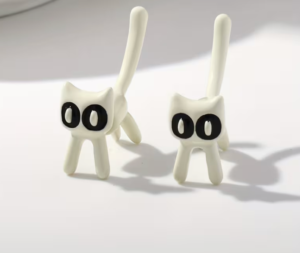 White cartoon kitty earrings with expressive eyes and tall tails