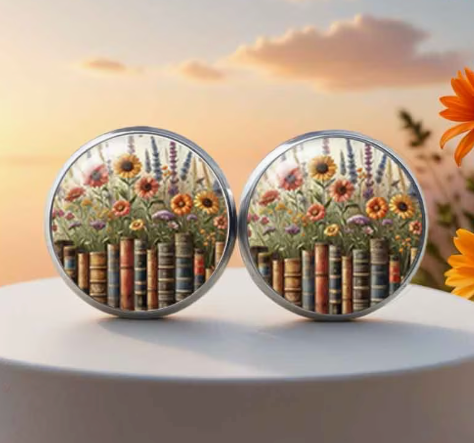 Round silver-tone glass stud earrings featuring colorful wildflowers blooming above a row of vintage-style books