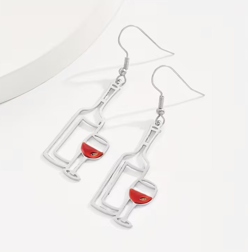 Silver wine bottle and wine glass dangle earrings with red wine enamel detail shown on a white background.