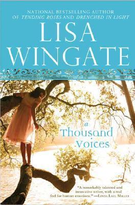 Book cover of 'A Thousand Voices' by Lisa Wingate with a woman standing on a log over water.