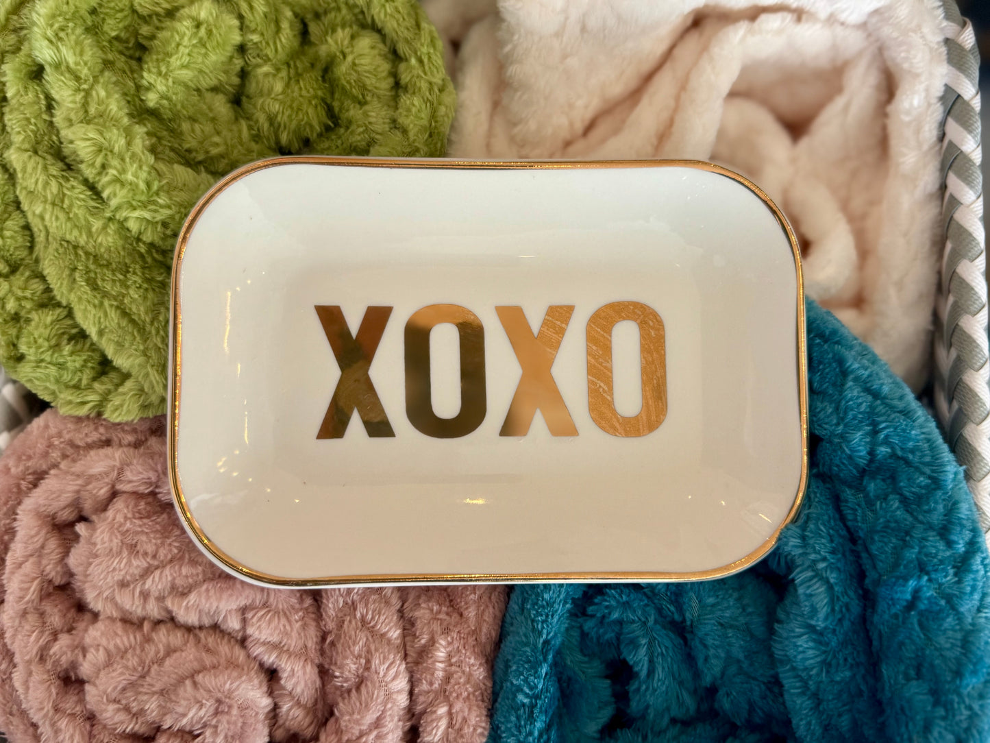 A white Valentine’s jewelry dish with gold font that reads “XOXO,” perfect for holding rings, earrings, or small keepsakes.