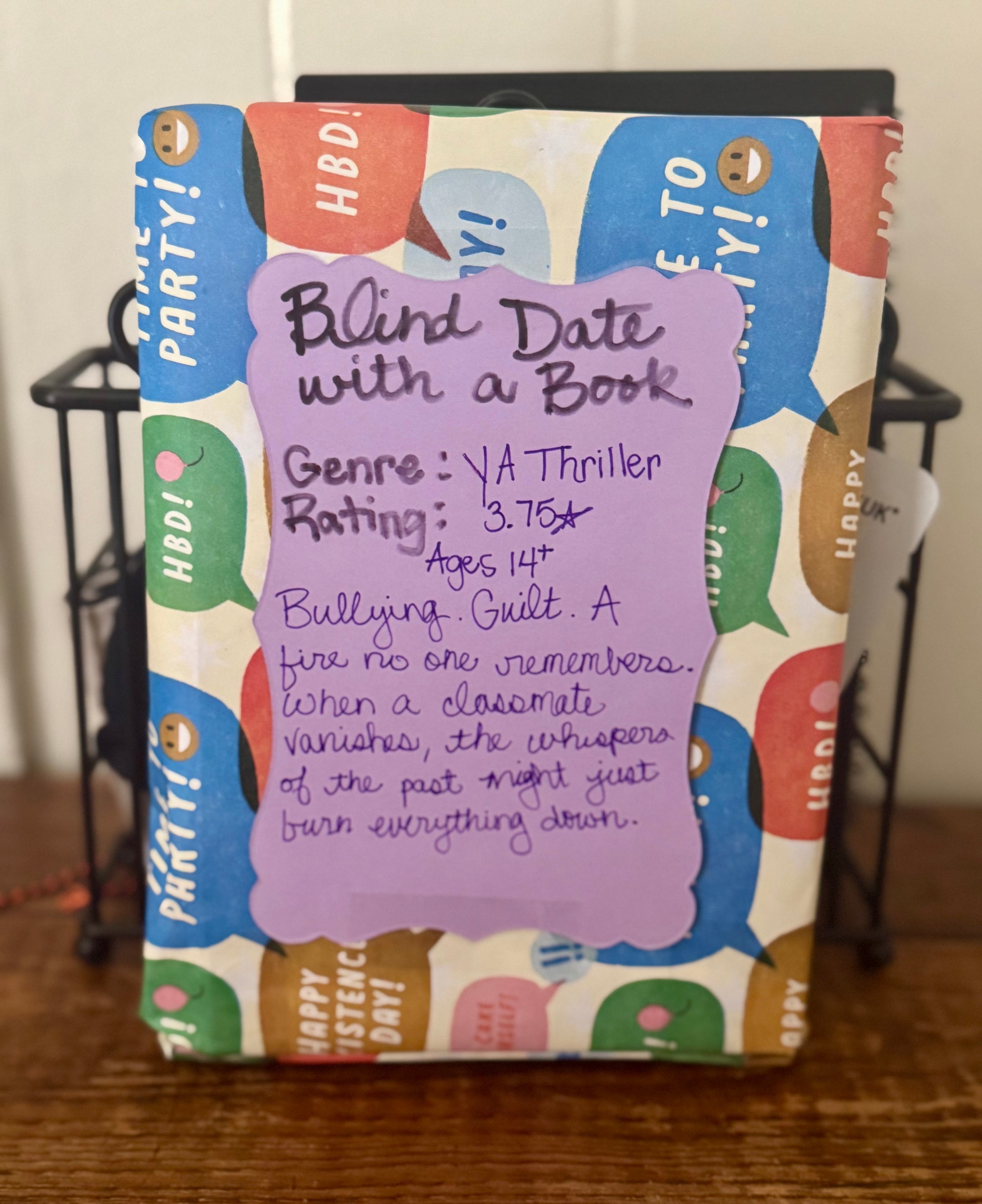 Book with colorful design and a purple label on a wooden surface